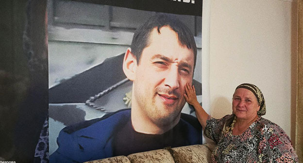 Эсет Умарова рядом с портретом своего сына Мовсара. Фото: https://t.me/no_torture/3635 Эсет Умарова рядом с портретом своего сына Мовсара. Фото: https://t.me/no_torture/3635