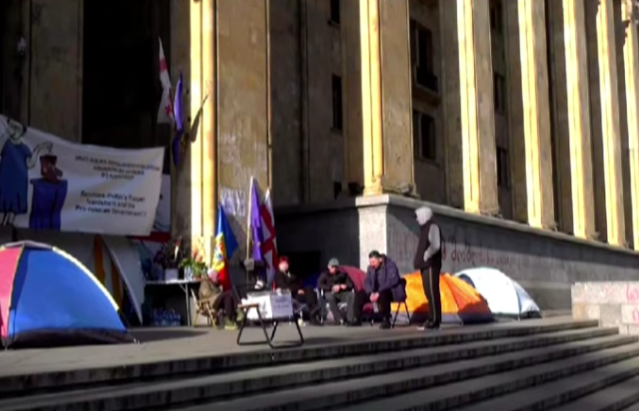 Голодающие у парламента Грузии. Стоп-кадр видео TV Pirveli от 22.11.25, https://www.youtube.com/watch?v=j7p3dfH4wUk&t=69s. Голодающие у парламента Грузии. Стоп-кадр видео TV Pirveli от 22.11.25, https://www.youtube.com/watch?v=j7p3dfH4wUk&t=69s.