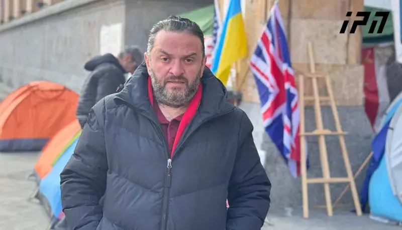 Участник голодовки у парламента Грузии. 27 ноября 2025 г. Фото: https://www.interpressnews.ge/ka/article/855776-parlamenttan-shimshilobas-am-droistvis-6-piri-ganagrzobs-ramdenimem-janmrtelobis-mdgomareobis-gartulebis-gamo-shimshilobis-akcia-shecqvita Участник голодовки у парламента Грузии. 27 ноября 2025 г. Фото: https://www.interpressnews.ge/ka/article/855776-parlamenttan-shimshilobas-am-droistvis-6-piri-ganagrzobs-ramdenimem-janmrtelobis-mdgomareobis-gartulebis-gamo-shimshilobis-akcia-shecqvita