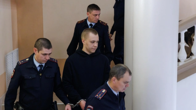Никита Журавель в окружении силовиков. Скриншот фото Алексея Волхонского/V1, https://v1.ru/text/criminal/2025/10/29/76097063/. Никита Журавель в окружении силовиков. Скриншот фото Алексея Волхонского/V1, https://v1.ru/text/criminal/2025/10/29/76097063/.