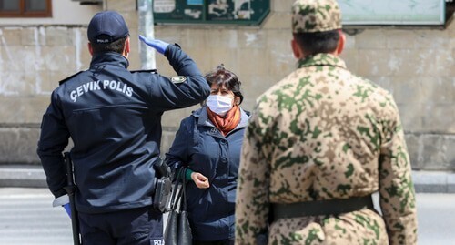 Полицейский останавливает женщину на улице Баку во время карантина. Фото Азиза Каримова для "Кавказского узла". Полицейский останавливает женщину на улице Баку во время карантина. Фото Азиза Каримова для "Кавказского узла".