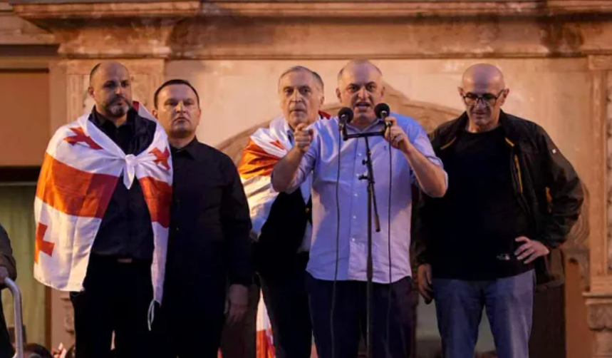 Слева направо: Иракли Надирадзе, Паата Манжгаладзе, Паата Бурчуладзе, Муртаз Зоделава, Лаша Беридзе на акции 04.10.25. Скриншот фото "Интерпрессньюс" https://www.interpressnews.ge/ru/article/174819-po-delu-4-oktiabria-paata-burchuladze-murtaz-zodelava-iraklii-nadiradze-lasha-beridze-i-paata-mandzhgaladze-prigovoreny-k-7-tornike-mchedlishvili-nika-gventsadze-iraklii-chkhvirkiia-k-5-a-iraklii-shaishmelashvili-k-2-godam-lisheniia-svobody. Слева направо: Иракли Надирадзе, Паата Манжгаладзе, Паата Бурчуладзе, Муртаз Зоделава, Лаша Беридзе на акции 04.10.25. Скриншот фото "Интерпрессньюс" https://www.interpressnews.ge/ru/article/174819-po-delu-4-oktiabria-paata-burchuladze-murtaz-zodelava-iraklii-nadiradze-lasha-beridze-i-paata-mandzhgaladze-prigovoreny-k-7-tornike-mchedlishvili-nika-gventsadze-iraklii-chkhvirkiia-k-5-a-iraklii-shaishmelashvili-k-2-godam-lisheniia-svobody.