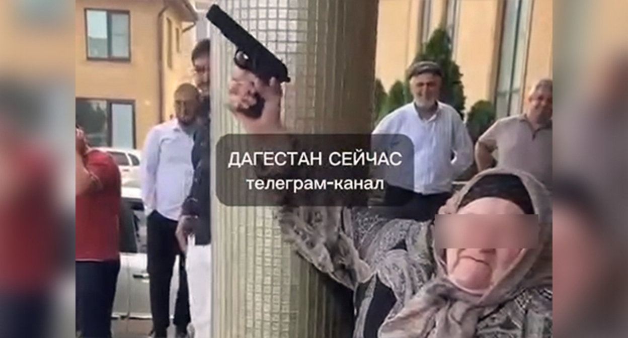 Пожилая жительница Хасавюрта производит выстрел из пистолета во время свадьбы. Стоп-кадр из видео https://www.instagram.com/p/DapuiBgM6xA (деятельность компании Meta (владеет Facebook, Instagram и WhatsApp) запрещена в России)