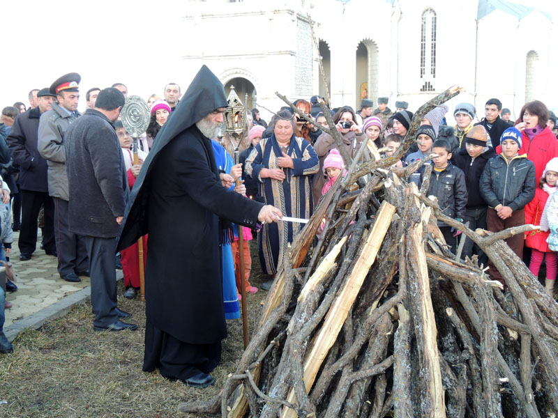 архиепископ Паргев Србазан зажигает костёр свечой из церкви. архиепископ Паргев Србазан зажигает костёр свечой из церкви.