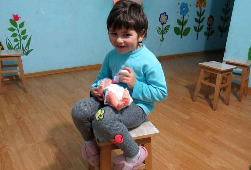 Малышка Тая со своей любимой куклой, которую с удовольствием кормит.
